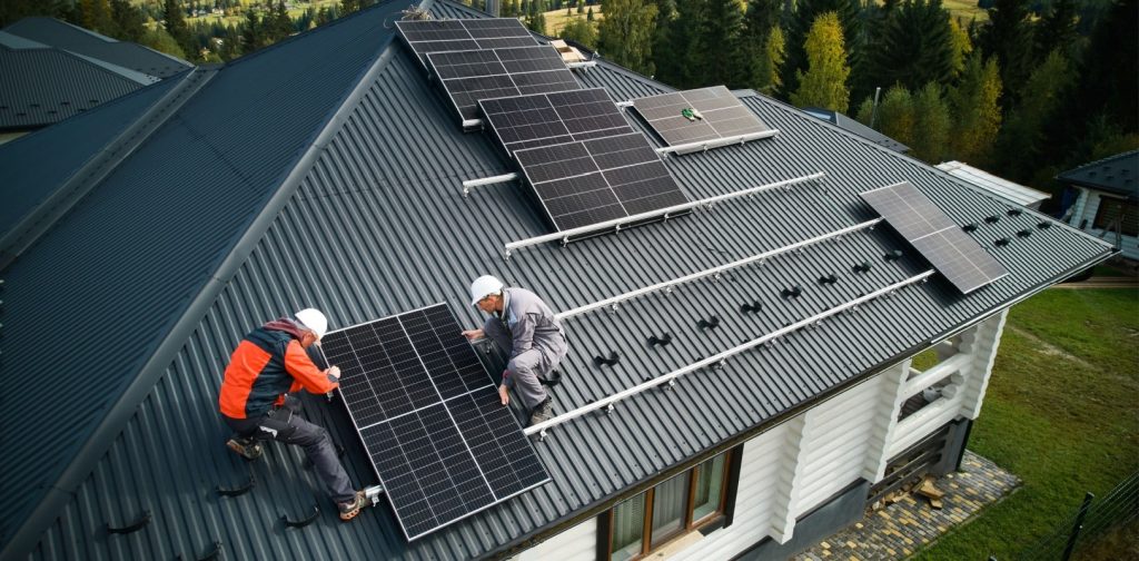 Technicians building solar module on roof of house